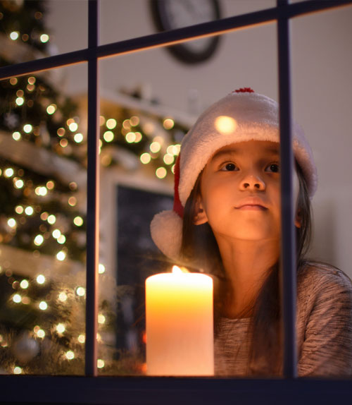 Девочка смотрит в окно, в ожидании Рождества